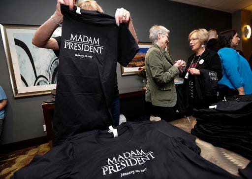 In this Nov. 8, 2016, file photo, Kathy Schmitt, left, folds T-shirts that she designed, declaring “Madam President,” for sale at an election night party for Democrats in Seattle. Copies of a one-off edition of Newsweek featuring Hillary Clinton that carried the title “Madam President” that were recalled following Clinton’s loss in the Nov. 8, 2016, election are being sold for hundreds of dollars on eBay. (AP Photo/Elaine Thompson, File)