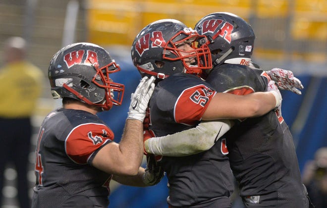 West Allegheny's Anthony Tautkus (44), Matt Holmes (54) and Will Weber celebrate a touchdown during the WPIAL Class 5A football championship game at Heinz Field.