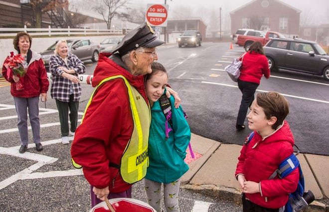 Photo by Warren Westura/New Jersey Herald —  From left, crossing guard Dorothy Kays hugs student Lily Tabachnik, 11, while brother Sam, 7, watches.