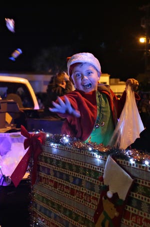 A child flings candy from a float during the Panama City Jaycees Christmas Parade in December 2015. HEATHER HOWARD/THE NEWS HERALD