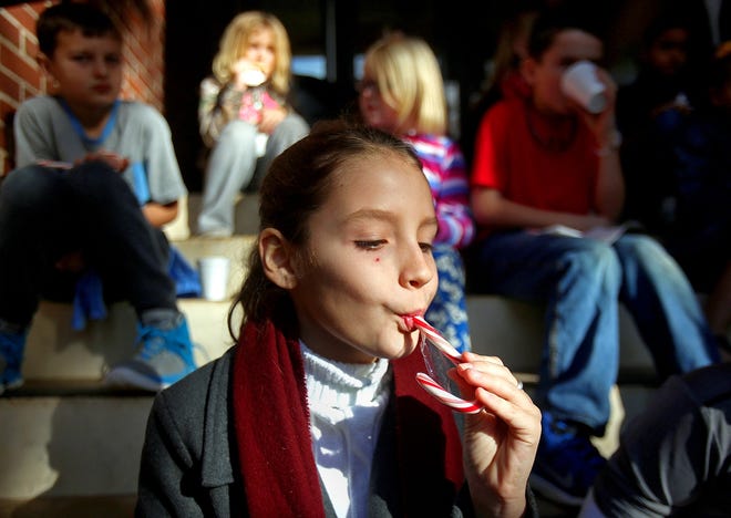 Brittany Randolph/The StarSavannah Stohoviak, 10, eats a candy cane after decorating the Central Services Christmas tree with other Casar Elementary School students on Friday.