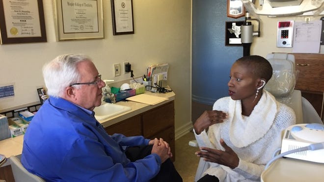 Deloris Fields describes what is happening in her mouth to Dr. Kent Macaulay. Her breast cancer treatment has damaged her teeth. He and other Capital Area Dental Foundation dentists have donated services to eight people in the Season for Caring program this year.