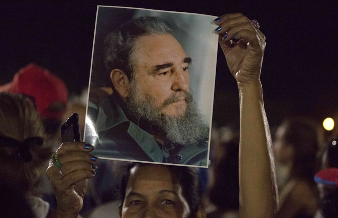 A woman holds a picture of late Fidel Castro during a rally at Revolution Plaza in Havana during the mourning period for the longtime Cuban leader. AP PHOTO BY DESMOND BOYLAN