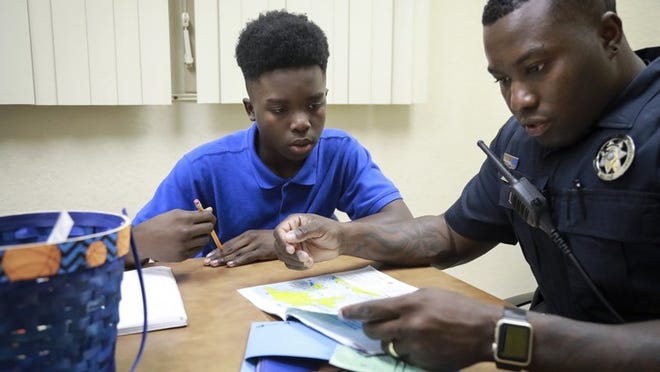 James Smith (age 13) is mentored by Boynton Beach Police officer Jervis Daley as part of the Boys and Blue program at Congress Middle School Monday, November 28, 2016. “When I see James, I see myself,” said Daley. “We meet weekly. I take this seriously.” (Bruce R. Bennett / The Palm Beach Post)
