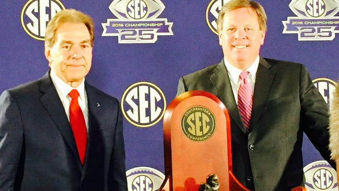 Alabama coach Nick Saban (left) and Florida coach Jim McElwain pose behind the trophy that awaits the winner of their game on Saturday in the Georgia Dome. (Garry Smits/The Times-Union).