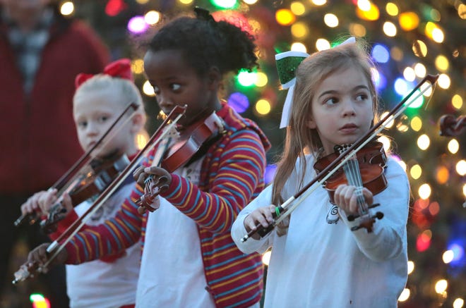 Jolie Walters, from left, Maya Hamilton and Anna James, with the Panama City Youth Orchestra, play Christmas carols Friday during the annual Christmas Tree Lighting Ceremony in downtown Panama City. HEATHER HOWARD/THE NEWS HERALD