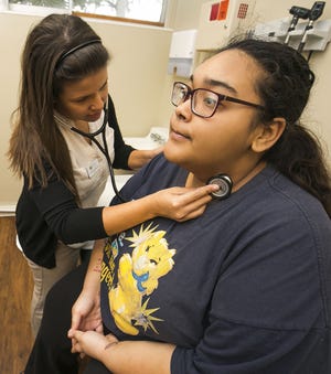 Nurse practitioner Yasmin Ramasco checks the heart beat on her patient Jenina Valentin, 18, at the Heart of Florida Health Center in Ocala last month. Heart of Florida faces significant budget cuts and is reviewing options and bringing in a consultant for advice. (Doug Engle/Ocala Star-Banner)2016