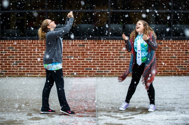Alexa Diser, left, and Joanna Bauza, right, of Belleville, Ill., try to catch snowflakes during the first snowfall of the season outside of Menard Hall on the campus of Lincoln Land Community College, Sunday, Dec. 4, 2016, in Springfield, Ill. Justin L. Fowler/The State Journal-Register