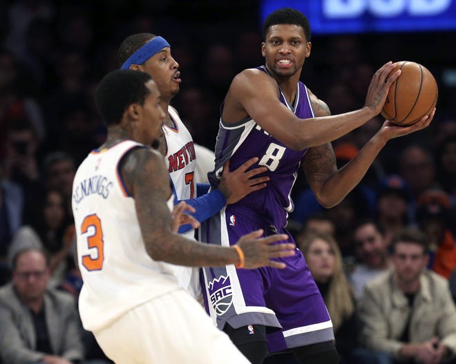 Kings' Rudy Gay, right, looks to pass around Knicks' Brandon Jennings, left, and Carmelo Anthony during the second half. The Associated Press