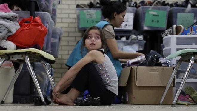 A young girl from Central America newly released after processing by the U.S. Customs and Border Patrol is fitted shoes at the Sacred Heart Community Center in McAllen last month.
