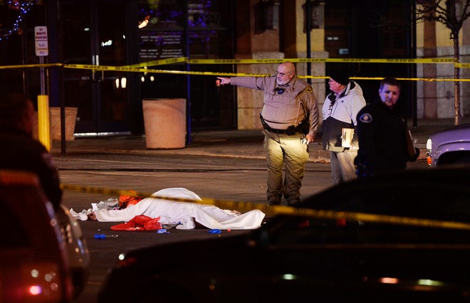 In this Dec. 4, 2016 photo, the body of a male suspect lies in a parking lot of the in American Fork, Utah, where he was shot and killed by police following a brief pursuit. Sheriff’s Sgt. Spencer Cannon said the man refused orders to drop his gun and officers wound up firing shots. (Francisco Kjolseth/The Salt Lake Tribune via AP)
