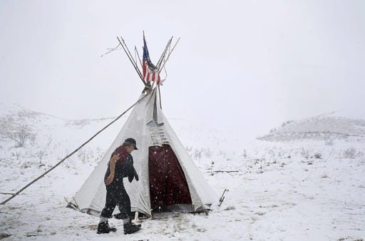 Vietnam veteran Allen Coomsta Matt walks into his teepee at the Oceti Sakowin camp where people have gathered to protest the Dakota Access oil pipeline as snow begins to fall Monday in Cannon Ball, N.D. AP photo