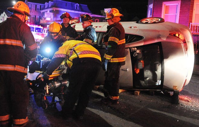 After being extricated from her upended vehicle by Fall River Fire Department personnel, a woman is prepared for ambulance transport. Alone in the vehicle, the driver appeared to be conscious at the scene of the two-car rollover that occurred on North Main Street near the corner of Pierce Street, at around 6 p.m. Monday.