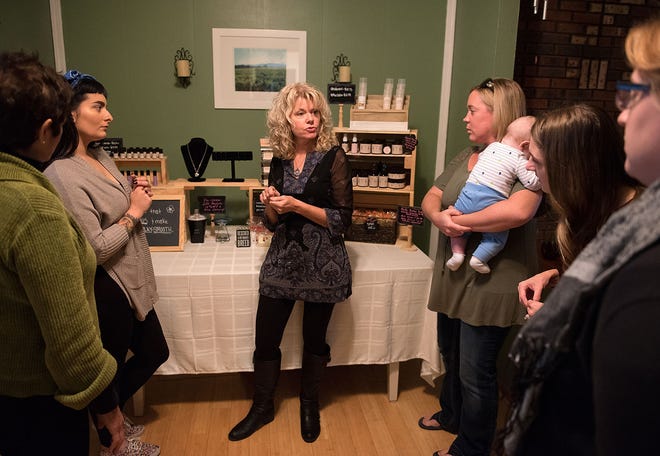 Christine's Garden of Beauty CEO Christine Mauro (center) and Vice President Jamie Hofmann (second from left) talk to guests about their organic skincare, pet care and aromatherapy products during a home party at Mauro's house Friday, Nov. 18, 2016, in Bensalem.