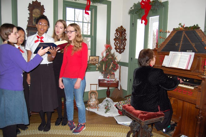 Singing carols at the Will Carleton Poorhouse Saturday are Felicia Vinatieri, Chloe and Olivia Trichka-Stuchell and Gretchen and Maria Birzer. NANCY HASTINGS PHOTO