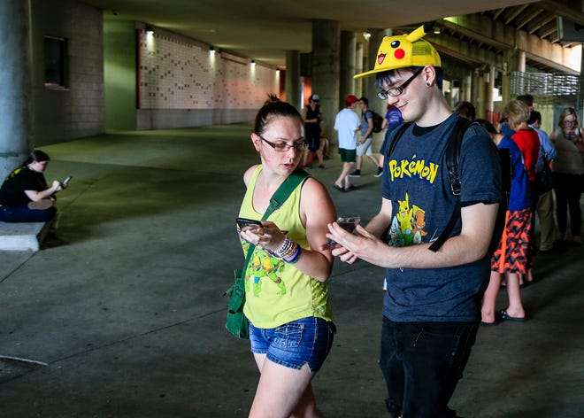 FILE - In this July 14, 2016, file photo, players look at their phones during a "Pokemon Go" event at Memorial Stadium in Lincoln, Neb. The Rio Olympics, the American presidential election and Pokemon Go were the top global trends on Twitter in 2016. (AP Photo/Nati Harnik, File)