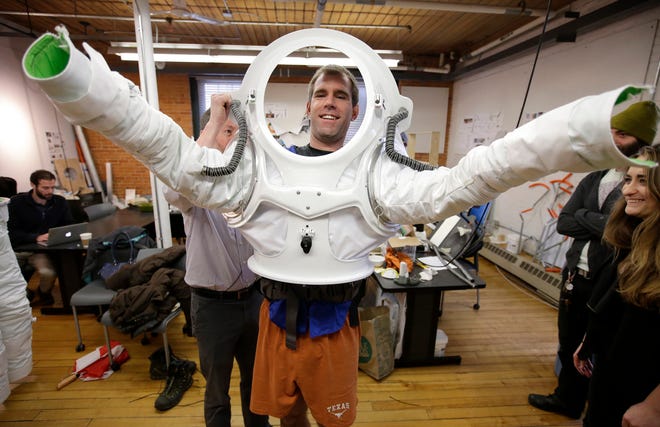 In this Monday, Dec. 5, 2016 photo, Andrzej Stewart, the chief engineering officer on a year-long Mars simulation mission that ended in August, puts on a new space suit at the Rhode Island School of Design (RISD) in Providence, R.I. RISD created the new space suit for scientists to wear on the next Mars simulation mission in 2017 in Hawaii. (AP Photo/Steven Senne)