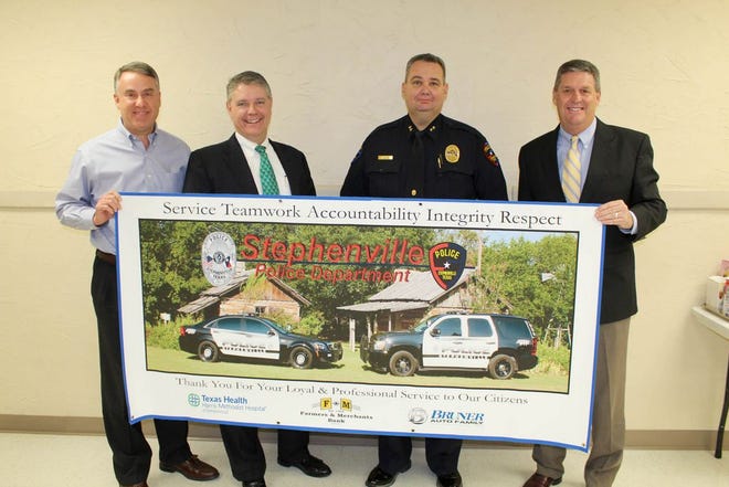 Stephenville Police Chief Jason King, second from right, accepts a banner donated by (left to right) Greg Bruner, Chris Leu and Joe Thompson.