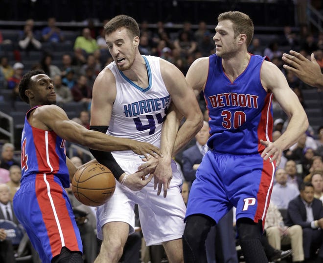Charlotte Hornets' Frank Kaminsky III (44) is fouled as he drives between Detroit Pistons' Jon Leuer (30) and Ish Smith (14) during the first half of an NBA basketball game in Charlotte, N.C., Wednesday, Dec. 7, 2016. (AP Photo/Chuck Burton)