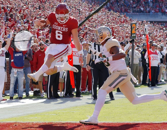 Oklahoma quarterback Baker Mayfield (6) leaps in for a touchdown ahead of Baylor safety Davion Hall. Mayfield was selected to the AP All Big 12 team on Tuesday and is one of five Heisman Trophy finalists. (AP Photo/File)