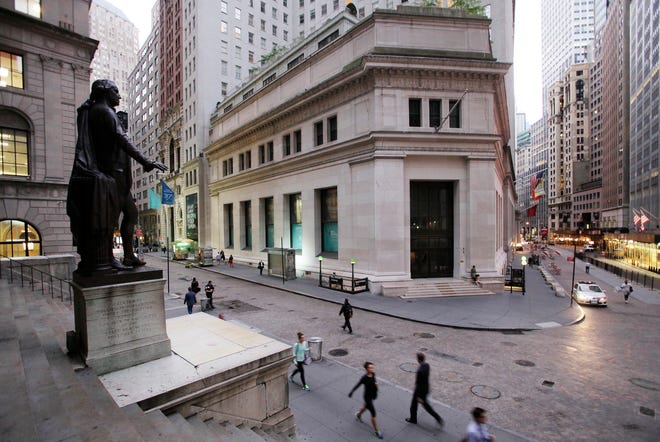FILE - In this Oct. 8, 2014, file photo, people walk to work on Wall Street beneath a statue of George Washington, in New York. Global shares rose on Thursday, Dec. 8, 2016, following upbeat trade data from China. (AP Photo/Mark Lennihan, File)