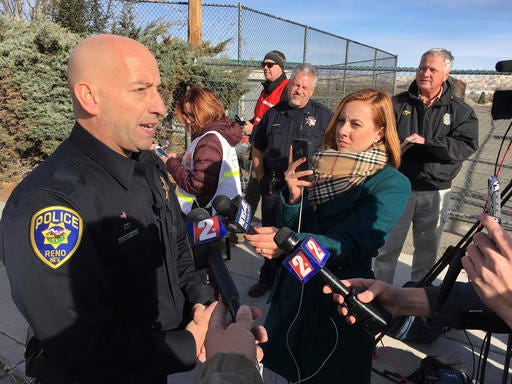 Reno police officer Tim Broadway briefs reporters outside Hug High School on the north side of Reno, Nev., on Wednesday, Dec. 7, 2016 after a Washoe County School District police officer shot a student following a disturbance at the school. The student was taken to a Reno hospital where there was no immediate word on the student's condition. (AP Photo/Scott Sonner)