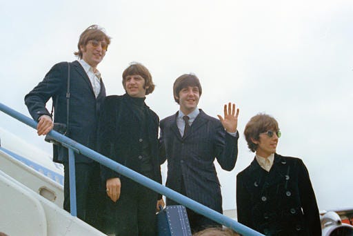 FILE - This 1966 file photo shows The Beatles, from left, John Lennon, Ringo Starr, Paul McCartney and George Harrison as they leave London Airport on their trip to the U.S. and Canada. Hundreds of books have been written about the band, but none with such care and authority as those by the 58-year-old British author Mark Lewisohn. Lewisohn is in the midst of a 3-volume biography of the Beatles and most recently contributed text for a coffee table book about their landmark film “A Hard Day’s Night.” (AP Photo/File)