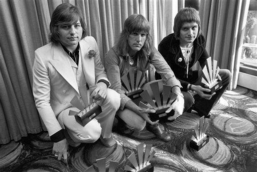 FILE - This is a Sept. 30, 1972 file photo of the members of the rock band Emerson, Lake and Palmer,Greg Lake, left Keith Emerson, centre, and Carl Palmer after an award ceremony in London . Greg Lake, the prog-rock pioneer who co-founded King Crimson and Emerson, Lake and Palmer, has died. He was 69. Lake died Wednesday Dec, 7, 2016 after "a long and stubborn battle with cancer," according to his manager. (PA File via AP)