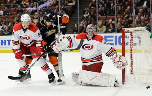 Carolina Hurricanes' Ron Hainsey, left, and Anaheim Ducks' Ryan Kesler watch as the puck passes by Hurricanes goalie Cam Ward during the second period of an NHL hockey game Wednesday, Dec. 7, 2016, in Anaheim, Calif. (AP Photo/Jae C. Hong)