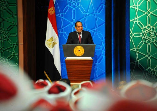 In this photo provided by Egypt's state news agency, MENA, Egyptian President Abdel-Fattah el-Sissi speaks to a gathering of Azhar clerics along with top government officials ahead of the Prophet's Birthday, a major Islamic holiday, at the Al-Azhar convention center, in Cairo, Egypt, Thursday, Dec. 8, 2016. El-Sissi defended the tough economic measures his government has undertaken, saying there was no alternative in the face of deteriorating economy. He said "structural reforms" are an imperative and that the measures are no "picnic." The remarks were the first by el-Sissi since the government's unprecedented floatation of the Egyptian pound, meant to ensure that Egypt qualifies for a 12 billion dollar loan from the IMF. (MENA via AP)