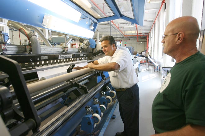 Machine operators David Rosati, left and Pete Townsend check a coating machine at Arkwright Advanced Coating in Scituate in 2010, the year the manufacturer celebrated its 200th anniversary. In 2014, workers displaced from the company received federal job-training assistance. JOURNAL FILES