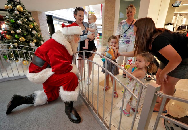 A child has his photo taken with Santa at the Santa HQ at the Chandler Mall, in Chandler, Ariz. The Santa experience has gotten amakeover as many malls install shows and games they hope will lure shoppers who are buying more online.