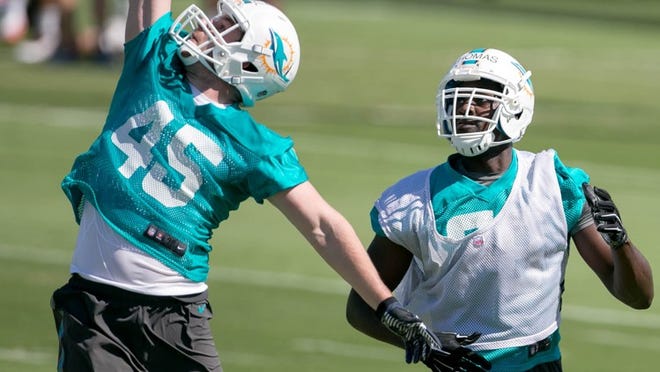 Miami Dolphins rookie linebacker Mike Hull (45) intercepts a pass intended for former University of Miami basketball player Joe Thomas (right) at Miami Dolphins rookie camp in Davie, Florida on May 8, 2015. (Allen Eyestone / The Palm Beach Post)