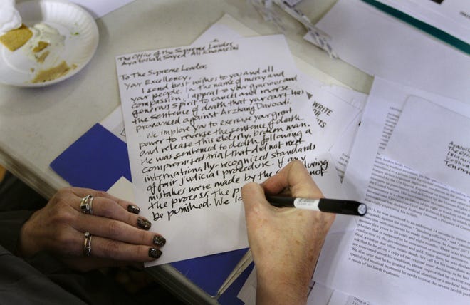 A volunteer writes a letter during Amnesty International's 29th annual "Write-a-thon," held at the parish house of the First Unitarian Church of Providence on Sunday. The letters are written in support of prisoners of conscience around the world. The Providence Journal/Kris Craig