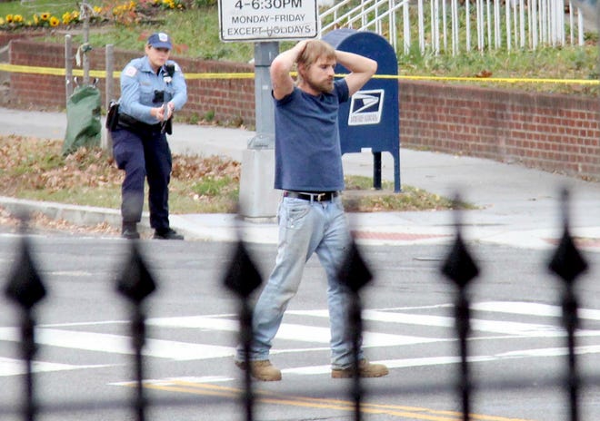 FILE- In this Dec. 4, 2016, file photo, Edgar Maddison Welch, 28 of Salisbury, N.C., surrenders to police in Washington. Welch, who fired an assault riffle multiple times inside a pizza restaurant in the nation’s capital while investigating an internet conspiracy theory is expected in court Tuesday, Dec. 13, for a hearing on whether he should stay in jail while he awaits trial. (Sathi Soma via AP, File)
