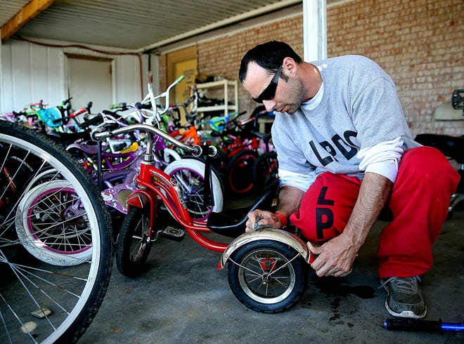 Lafourche Parish trusty Chad Sanchez works on a tricycle Monday in Galliano. Sanchez was preparing for the Sheriff's Office's Christmas bike giveaway. Abby Tabor/Staff-dailycomet/houmatoday