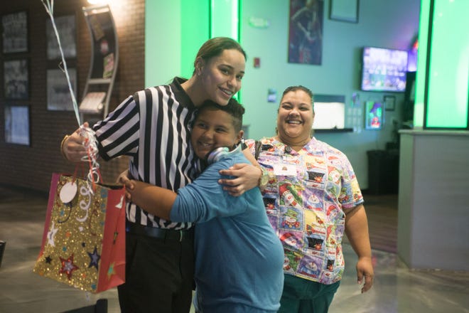Jadyn Brammeier Vasquez hugs Jonas Nielsen after receiving a gift of appreciation from him at ViaPort Florida on Thursday in Leesburg. On Dec. 4, Vasquez bought Jonas a pair of shoes he tried on after finding out that his mother couldn't afford them. (Cindy Dian / Correspondent)