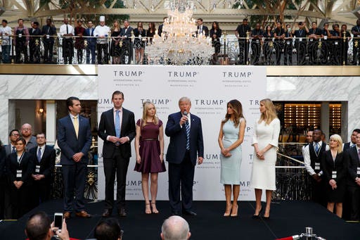 FILE - In this Oct. 26, 2016, file photo, Republican presidential candidate Donald Trump, accompanied by, from left, Donald Trump Jr., Eric Trump, Trump, Melania Trump, Tiffany Trump and Ivanka Trump, speaks during the grand opening of the Trump International Hotel- Old Post Office, in Washington. Donald Trumpâ€™s plan to hand control of his business to his children but hold onto ownership is drawing fire from government ethics experts. They say he should sell everything. (AP Photo/ Evan Vucci, File)