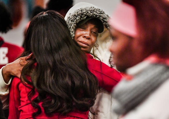 RON JOHNSON/Journal Star Friends and family share an embrace after a gathering for 22-year old Edward Moore, who was killed Sunday in Peoria, sponsored by the Peoria Community Against Violence group at the Gateway Building.