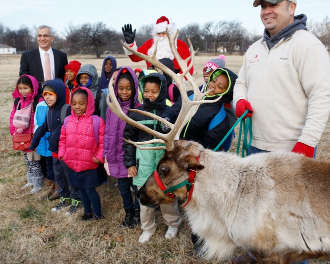 Students at the F.D. Moon Academy in Oklahoma City posed with a reindeer for a group picture behind the school in 2016 after participating in an event where they learned more about agriculture. At far right was reindeer wrangler Nick Ledbetter, while Jim Reese, Oklahoma's former agriculture secretary, was pictured far left. [Photo by Jim Beckel, The Oklahoman Archives]