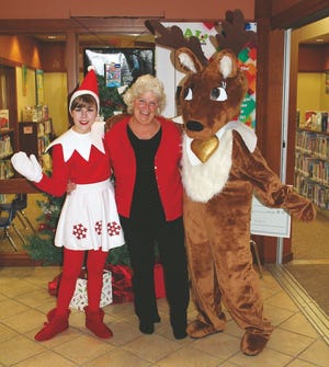 Snowflake the Elf, Friends of the Polk City Library President Krista Bowersox and Peppermint the Reindeer celebrate.