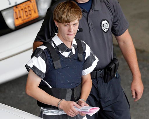 FILE - In this June 18, 2015 file photo, Charleston, S.C., shooting suspect Dylann Storm Roof is escorted from the Cleveland County Courthouse in Shelby, N.C. Prosecutors who wanted to show that Roof was a cruel, angry racist simply used his own words at his death penalty trial on charges he killed nine black people in June 2015 at a Charleston church. Roof's two-hour videotaped confession less than a day after the shooting and a handwritten journal found in his car when he was arrested were introduced into evidence Friday, Dec. 9, 2016. (AP Photo/Chuck Burton, File)