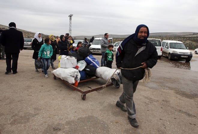 A Syrian man pulls their belongings after he was evacuated with his family from Aleppo, near Idlib, Syria, Friday, Dec. 16, 2016. Turkey’s Foreign Minister Mevlut Cavusoglu says 7,500 civilians have been evacuated from the Syrian city of Aleppo and that he has reached out to Tehran in a bid to keep the process on track.(AP Photo)
