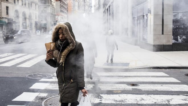 Commuters walk past a steam pipe in the cold in New York, Dec. 15, 2016. Winterâ€™s freeze in New York means some among the homeless seek warmth inside shelters, while others decide to stay the night inside Penn Station. (Christian Hansen/The New York Times)
