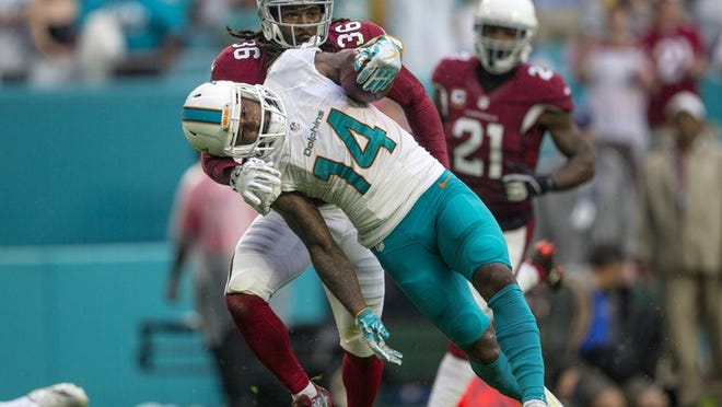 Miami Dolphins wide receiver Jarvis Landry (14), is brought down by Arizona Cardinals free safety D.J. Swearinger (36), after a long catch and run during third quarter action Sunday December 11, 2016 at Hard Rock Stadium in Miami Gardens. (Bill Ingram / The Palm Beach Post)