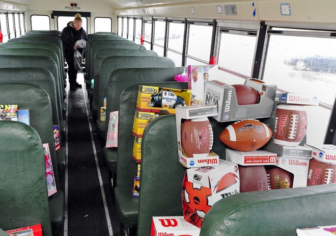 Heather Rego adds to the toys filling the bus at Wal-Mart in Fairhaven. DAVID W. OLIVEIRA/STANDARD-TIMES SPECIAL/SCMG
