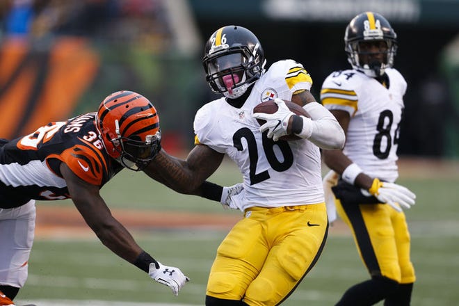 Pittsburgh Steelers running back Le'Veon Bell (26) runs against Cincinnati Bengals strong safety Shawn Williams (36) in the second half of an NFL football game Sunday in Cincinnati.
