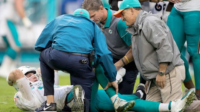 Miami Dolphins quarterback Ryan Tannehill (17) is attended by the medical staff after injuring his knee in the third quarter against the Arizona Cardinals at Hard Rock Stadium in Miami Gardens, Florida on December 11, 2016. (Allen Eyestone / The Palm Beach Post)