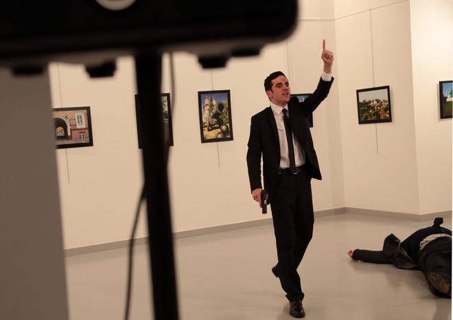 A man gestures near to Andrei Karlov on ground, the Russian Ambassador to Turkey at a photo gallery in Ankara, Turkey, Monday, Dec. 19, 2016. An Associated Press photographer says a gunman has fired shots at the Russian ambassador to Turkey. The ambassador’s condition wasn’t immediately known. (AP Photo/Burhan Ozbilici)