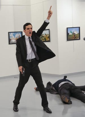 An gunman, identified as Mevlut Mert Altintas, gestures after shooting the Russian Ambassador to Turkey, Andrei Karlov, at a photo gallery in Ankara, Turkey, Monday. AP photo